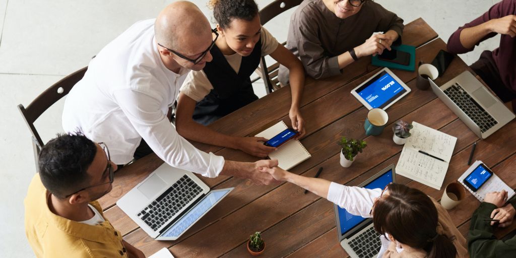 How to transfer a domain name - hands shaking across a table after a negotiation