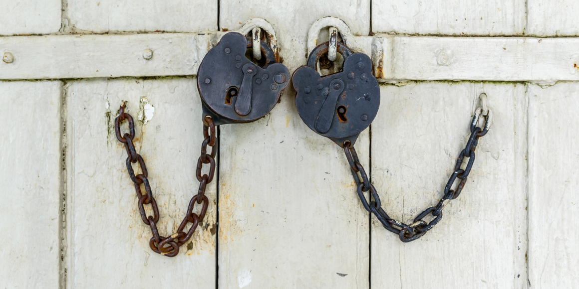 Two chains and locks on a barn door
