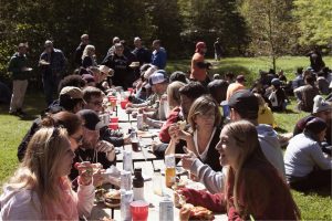 several people gather at picnic tables at the fireside conference