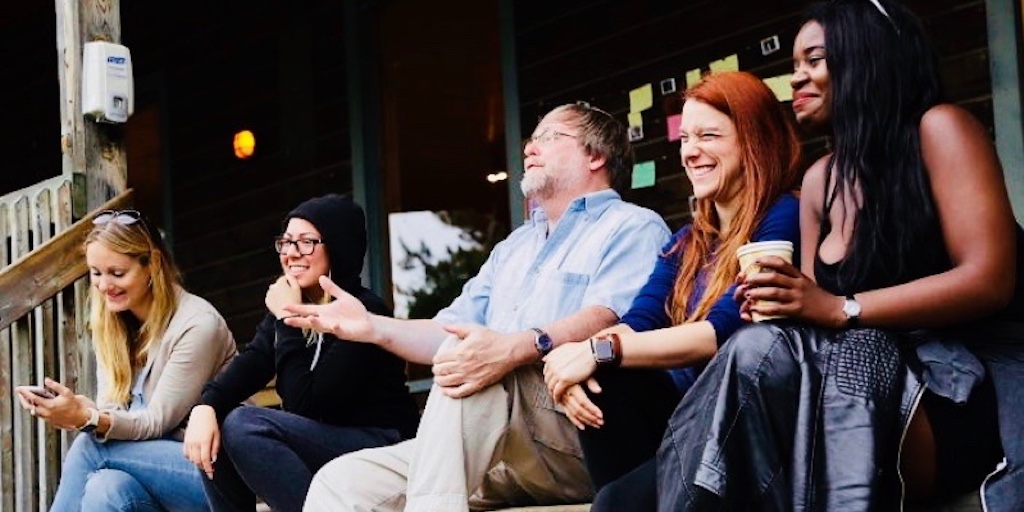 Several people sit on the porch at the fireside conference