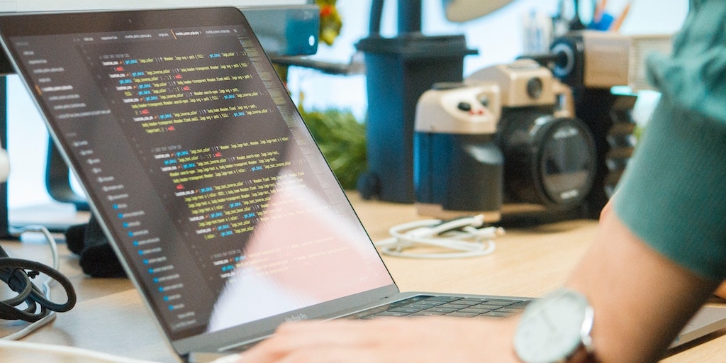 A coder works at a laptop